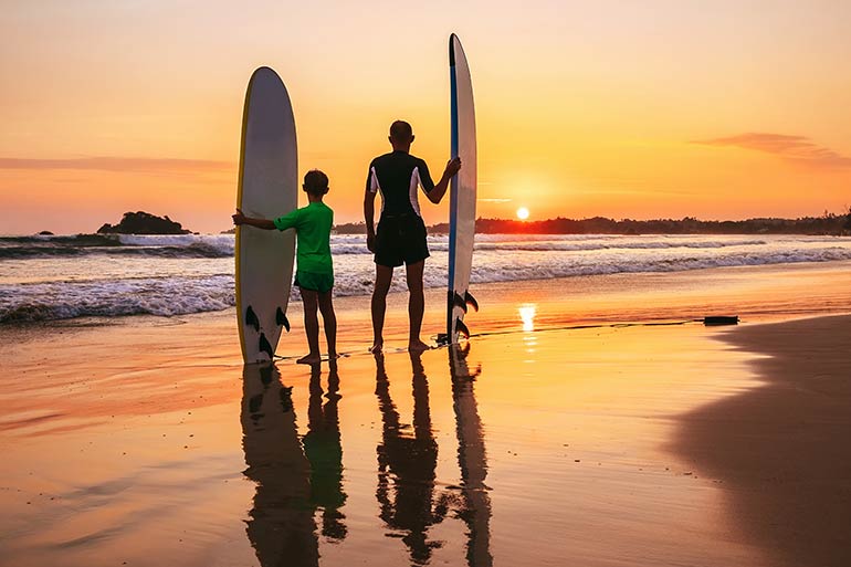 Father's Day, Dad and son surfers on the beach