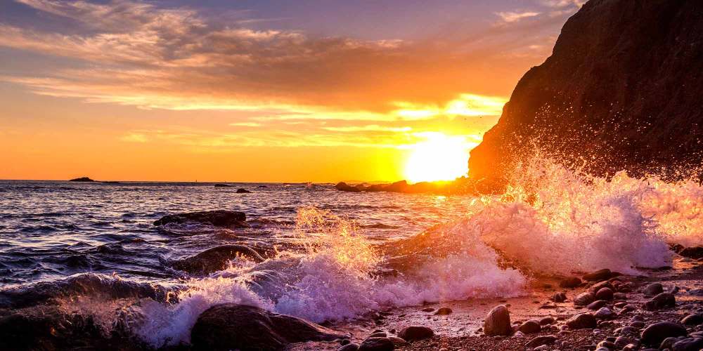 Sun sets behind Dana Point headland and ocean (© Mirecca | Dreamstime)