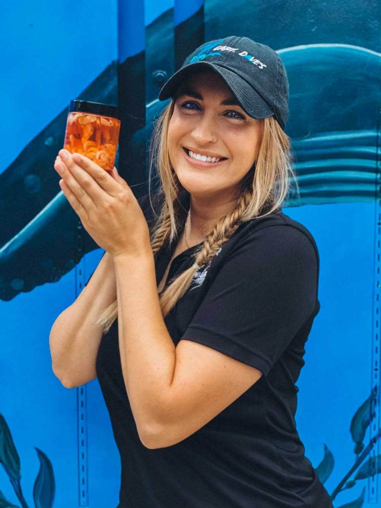 Marine naturalist holding sample krill jar