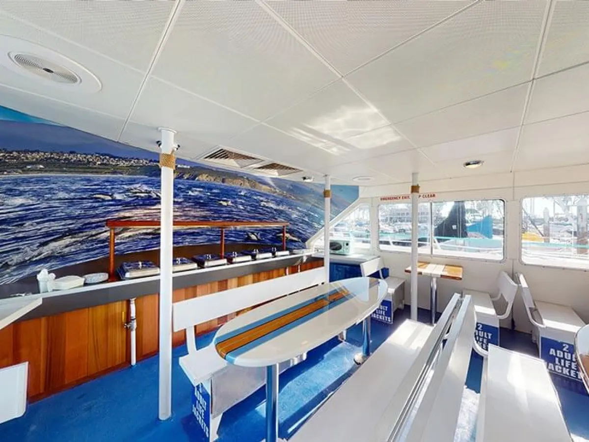 Buffet and bench seating with surfboard tables on main deck of Hoku Nai'a Whale Watching Power Catamaran off the coast of Dana Point, CA