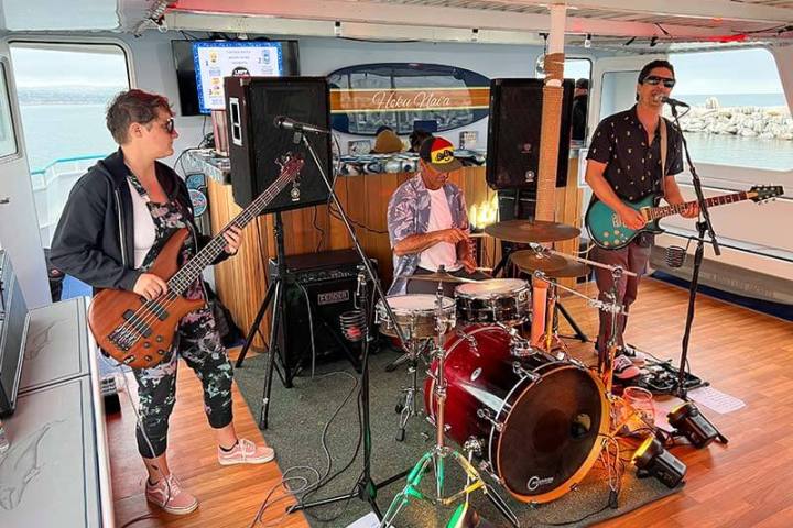 A live band plays during a sunset boat cruise on upscale power catamaran Hoku Nai'a