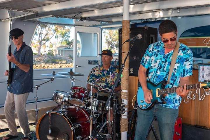 Three band members of Entropy play music on the boat during Brews Cruise beer tasting experience in Dana Point