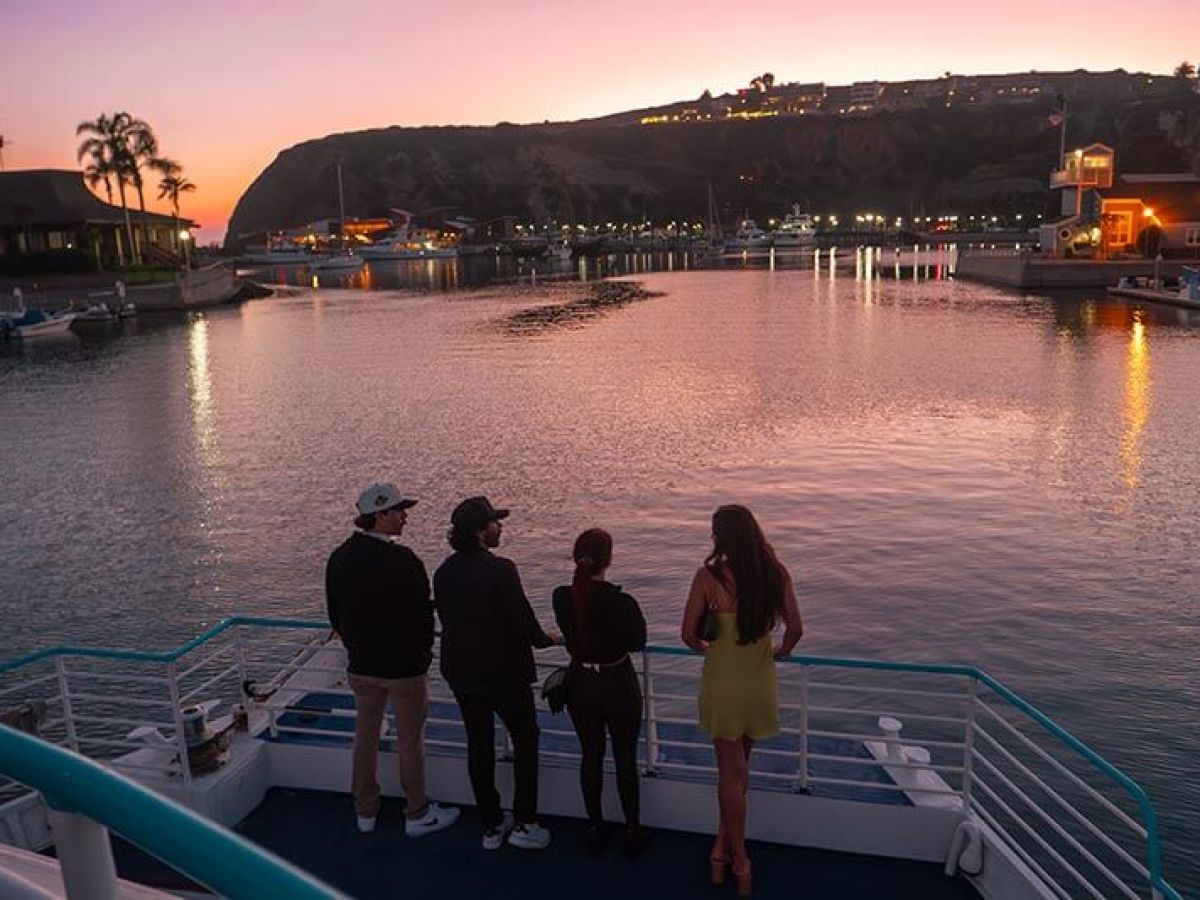 Guests enjoy the sunset during party boat cruise in Dana Point Harbor