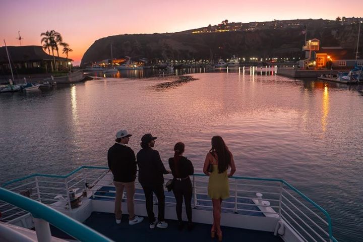 Guests enjoy the sunset during party boat cruise in Dana Point Harbor