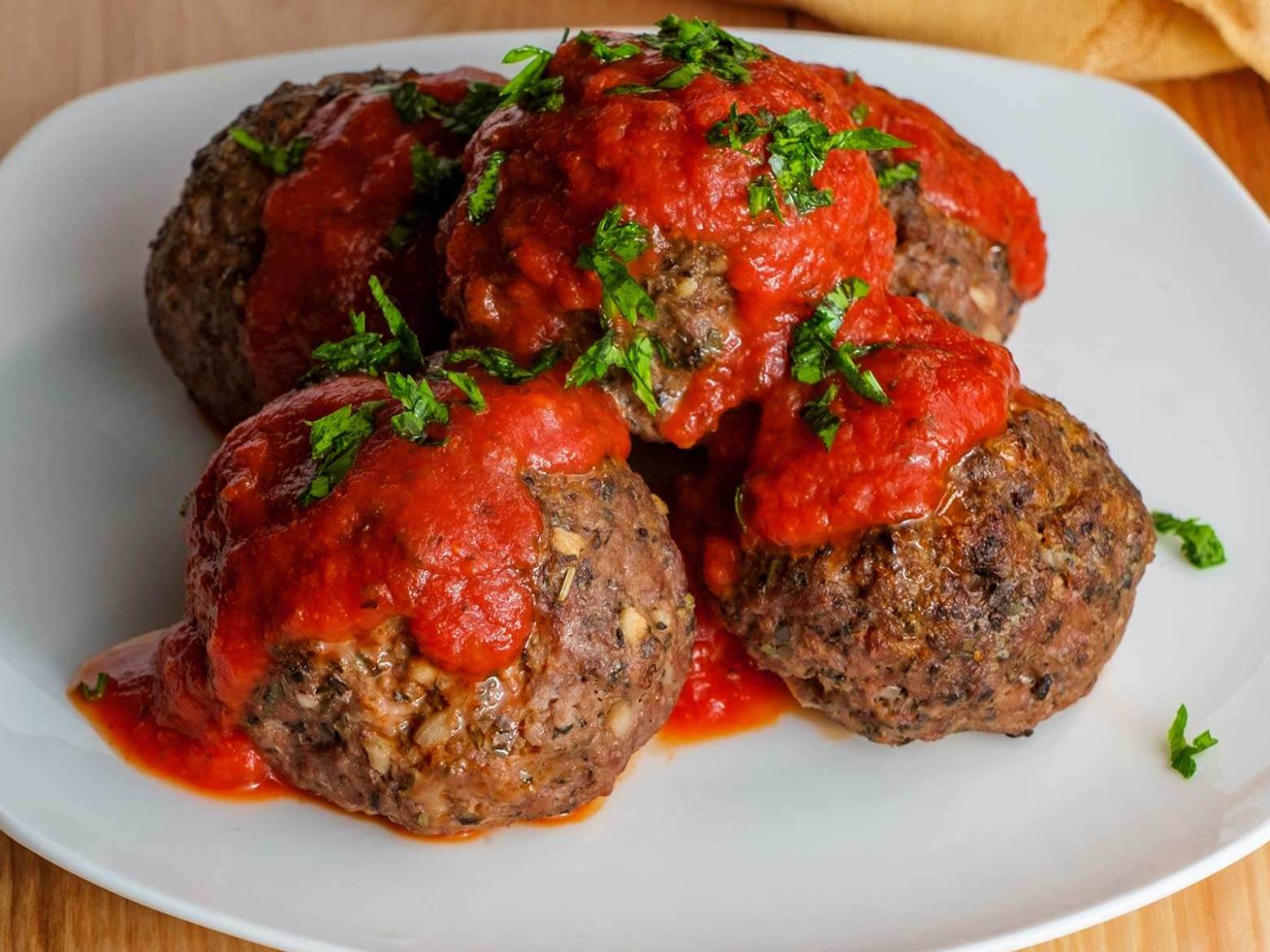 Four large Italian meatballs with marinara sauce