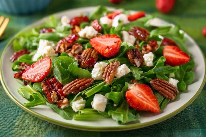 Close up concept of mixed greens salad with feta cheese, pecans, strawberries