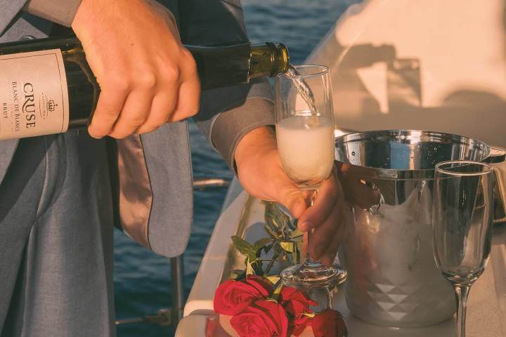 Pouring Champagne for a toast during marriage proposal at sea on a yacht off the coast of Dana Point, California