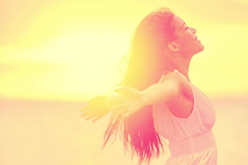 A happy woman enjoying the sunset