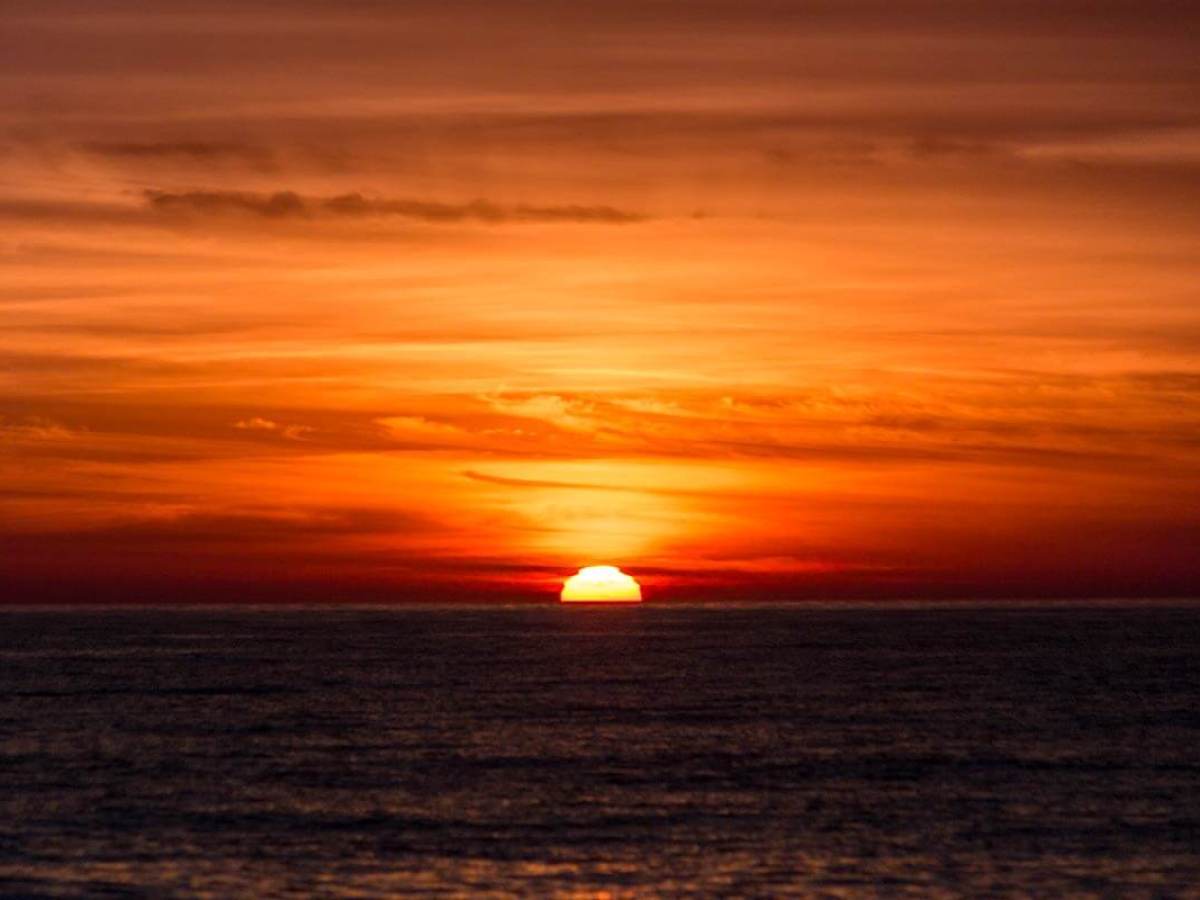 A bold orange sunset at sea off the coast of Dana Point, California